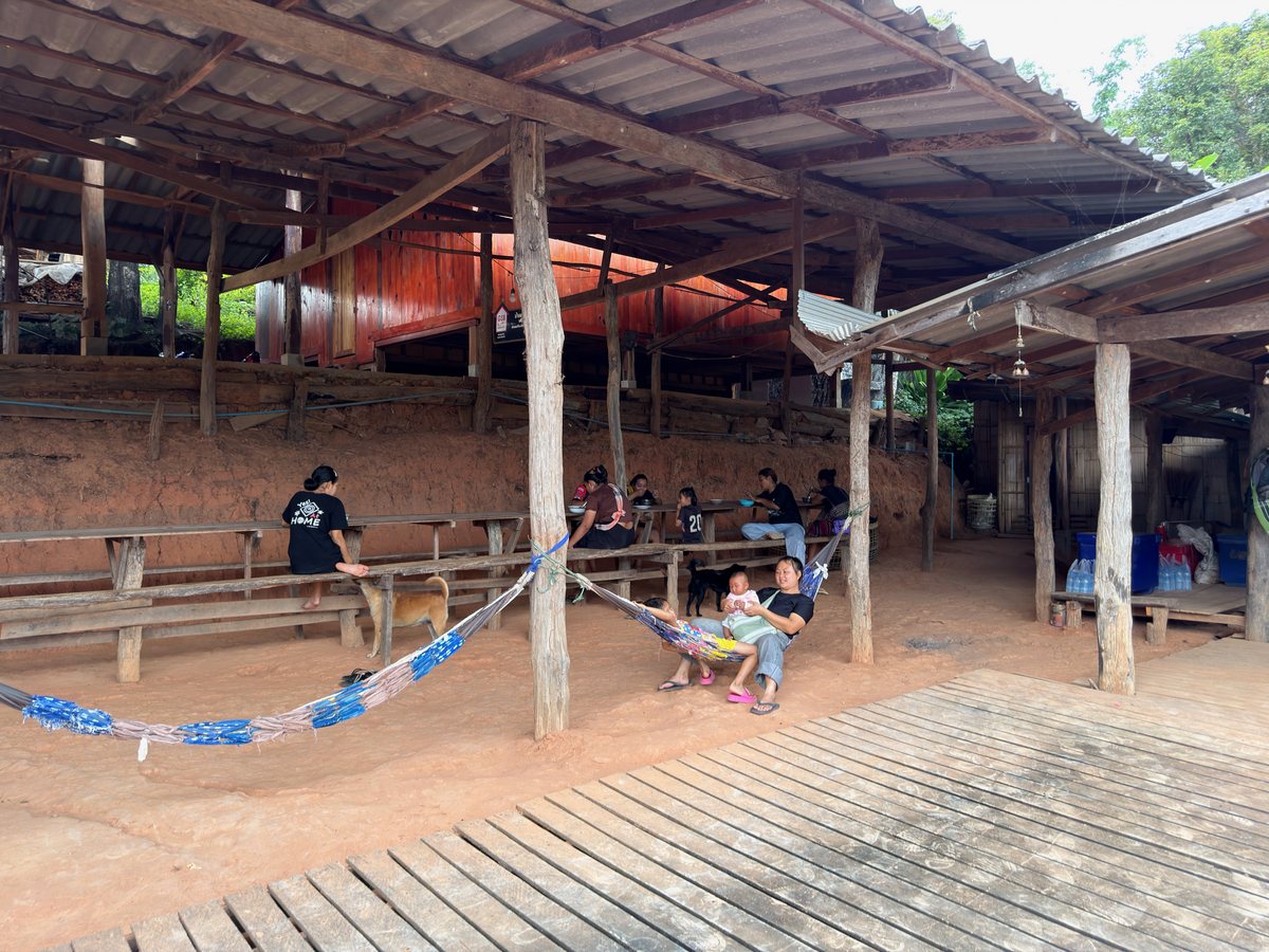 Villagers gathered beside long communal tables at a village home